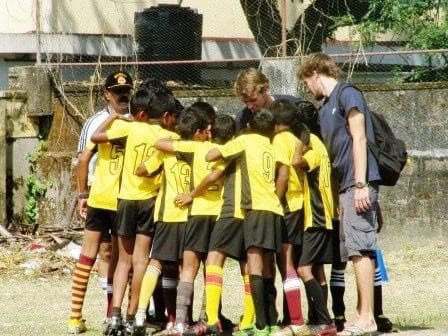 Football Coach and children huddle before a match