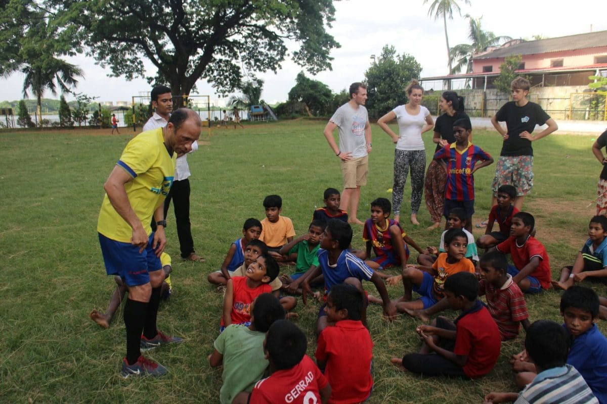 Sports coach and volunteers with children at a summer camp