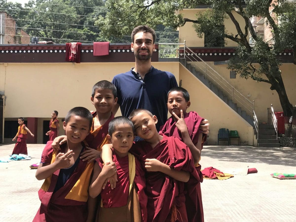 Volunteer posing with monk children in Nepal