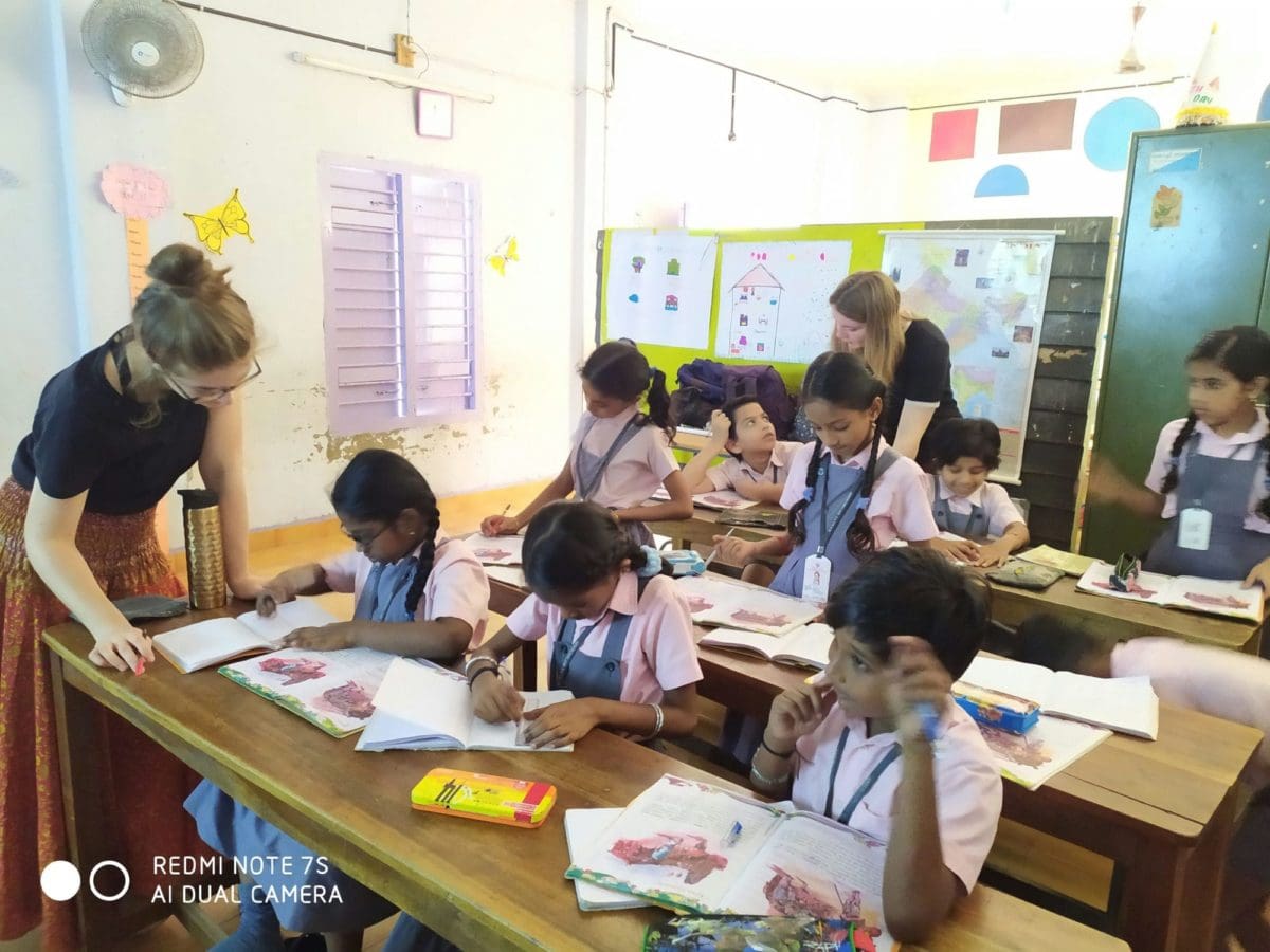 Volunteers helping the students in writting important words from the story book