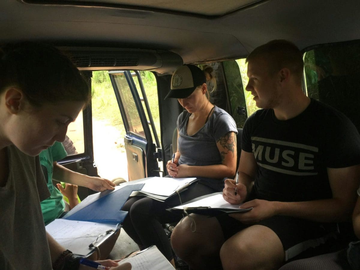 Wild Elephant Conservation volunteers in field jeep taking notes
